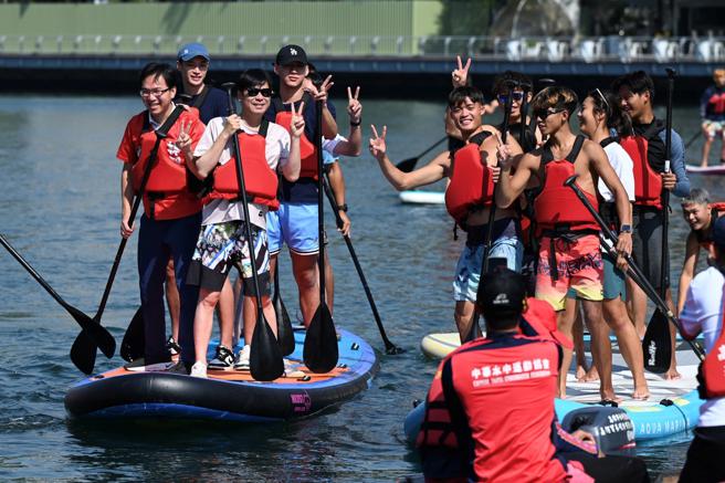 高雄市长陈其迈亲自体验立式划桨，并与现场学生们一起同乐合影。（图片来源：高雄市运发局提供）