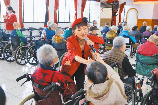 蔡衍明爱心基金会18日在桃园仁爱之家举行「让爷奶成为我们心中的宝」公益演唱会，5位歌手轮番上阵带来多首经典歌曲，歌手刘晏洁演出时与长辈互动，长辈开心比出手指爱心。（蔡明亘摄）