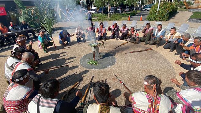 南投县信义乡地利、双龙、人和、潭南、洽波石共5部落猎人把猎具置于中央，并蹲下围成一圈，进行祭枪仪式。（林业署南投分署提供／杨静茹南投传真）