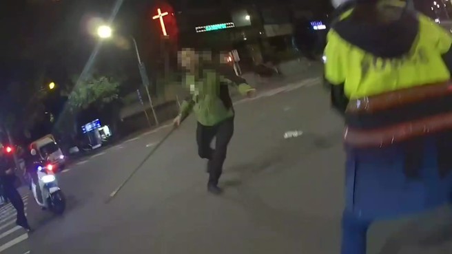 57岁潘姓男子持铁耙攻击员警。（翻摄画面）