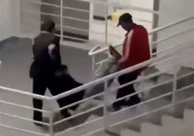 男学生头戴假髮扮女装进入女生宿舍楼求复合，却被工作人员反剪双手带出，之后被电晕抬下楼。（翻摄微博）