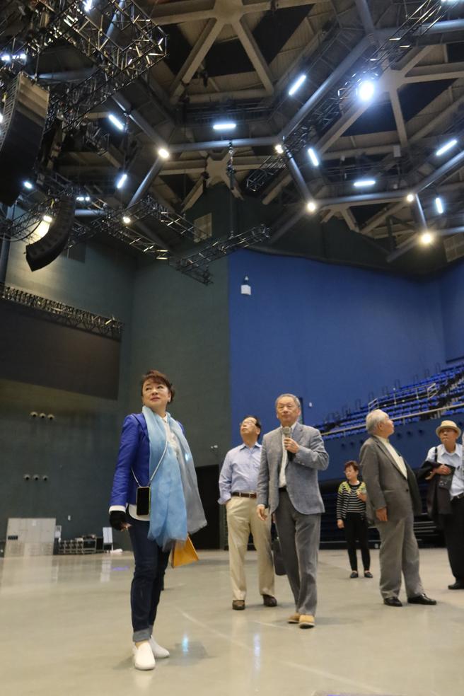 翁倩玉（左一）在海音馆内仔细聆听建筑设计的特色，并不时抬头观看屋顶六角形（图片来源：高雄流行音乐中心提供）
