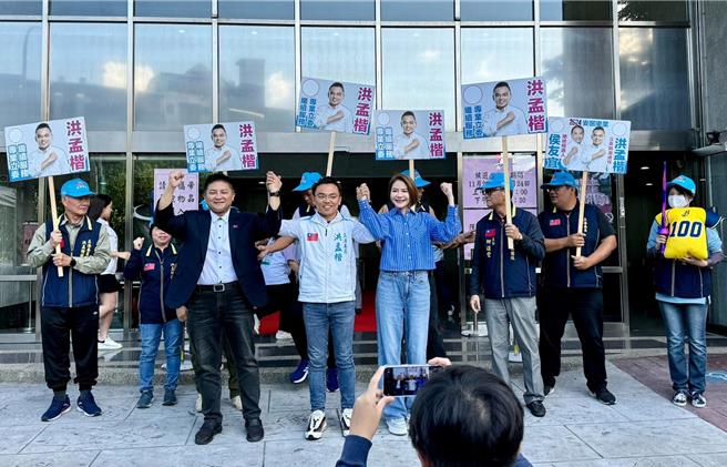 国民党不分区立委陈菁徽、吴宗宪21日陪同新北市立委一选区参选人洪孟楷登记，陈、吴致赠背号100号的「黄金战衣」及「斩妖除魔剑」，盼洪孟楷当100分的代议士，继续为民喉舌。（洪孟楷提供）