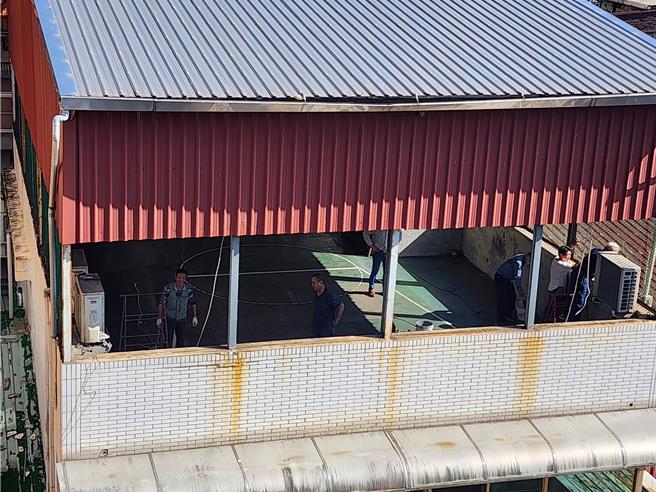 今天上午9時，張智倫雇用的工班，攜帶拆除工具，魚貫進入透天厝施工，先拆除頂樓的綠色圍網，再陸續拆除其他設施。（張智倫提供）