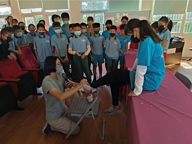 为恭医院骨科陈冠儒医师和復健师ANN，21日上午到竹南镇照南国小为球员做健康检查，復健师并亲自教导选手如何包扎关节处，确保球员在训练或比赛时能顾及健康及避免运动伤害。（为恭医院提供／谢明俊苗栗传真）