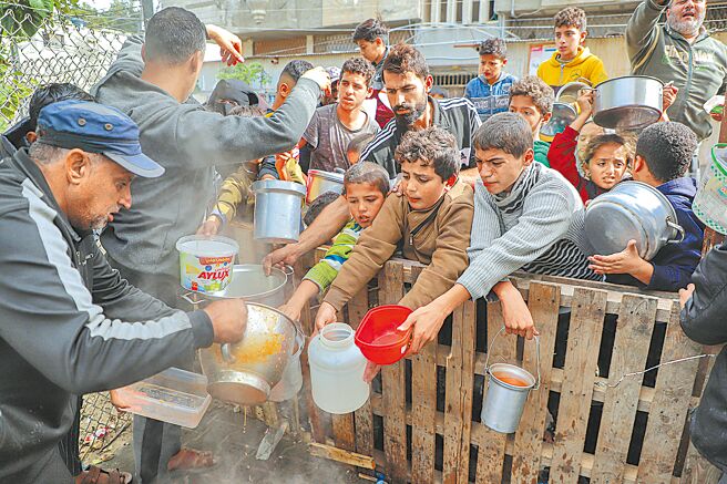 以國情報部長稱，要迦薩居民戰後移居國外。圖為領取救濟食物的巴勒斯坦人。（新華社）