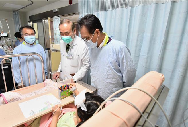 彰化縣副縣長林田富（右）、彰化縣政府教育處長蔡金田（左）在彰化基督教醫院副院長周志中（中）陪同下，22日探視竹塘鄉幼兒園娃娃車與BMW自小客車車禍中受傷的女童。（彰化縣政府提供／孫英哲彰化傳真）