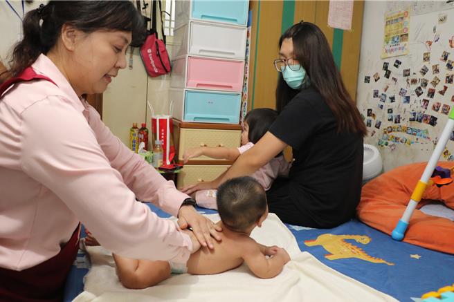 专业月嫂林惠敏（左）教小雯如何帮婴儿亲子按摩。（新北市社会局提供）