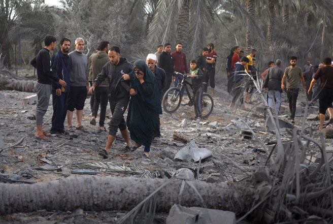 加薩走廊南部甘尤尼斯（Khan Younis）一處民宅22日遭遇以色列空襲，周遭巴勒斯坦人趕緊逃命。（路透）