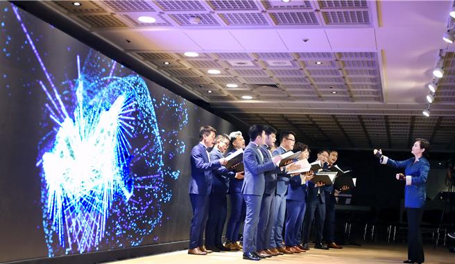 拉縴人合唱团21日演出《向生命乾杯》，音乐总监洪晴潆身穿感应装置，透过5G运算技术将指挥时的动作转化成抽象的画面，呈现在大型萤幕上。（范扬光摄）