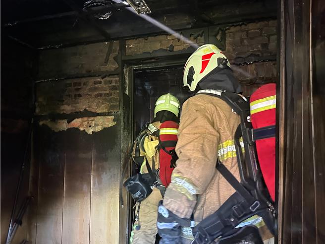 基隆市七堵区东新街1户民宅23日上午发生火警，消防人员获报并得知有一位身障屋主林男在屋内，赶至现场控制火势。消防员控制火势后，进入屋内搜救。（基隆市消防局提供／徐佑升基隆传真）