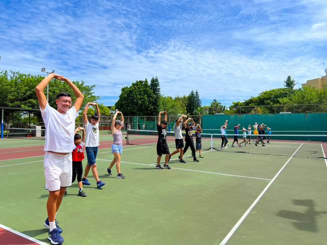 台師大網球隊員擔任助教帶領學員暖身。（太平洋網球發展基金會提供）
