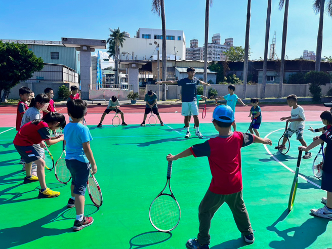 台師大網球隊員擔任助教帶領學員暖身。（太平洋網球發展基金會提供）