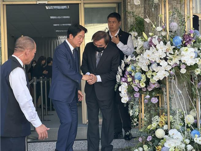民进党总统参选人赖清德（左二）23日专程赴日前辞世的奇美创办人许文龙追思会场致哀，向许文龙侄子握手致意。（曹婷婷摄）