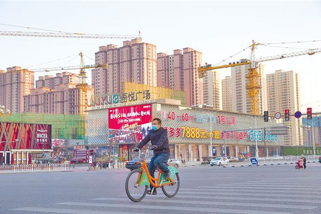 图为山西太原市民从建案前经过。（中新社）