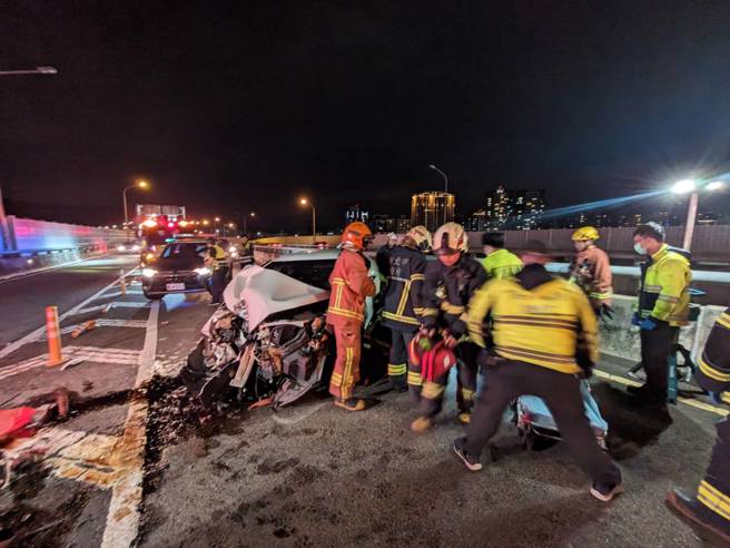 车祸现场白色轿车自撞分隔护栏，驾驶救出无生命迹象。（消防局提供）