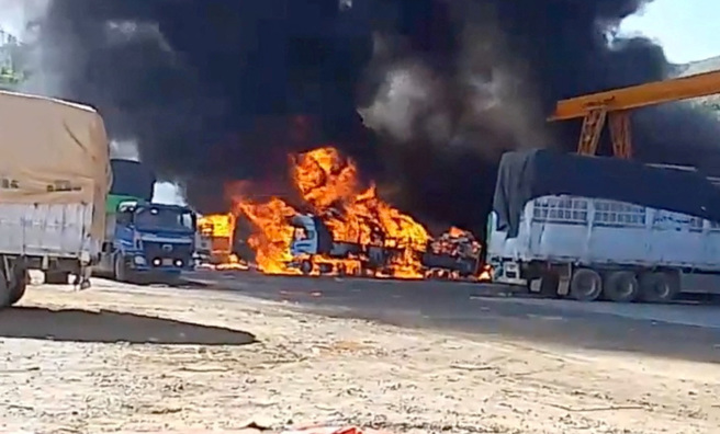 2023年11月23日发布的社群媒体影片截图显示，中缅边境附近几辆卡车正在燃烧。（路透社）