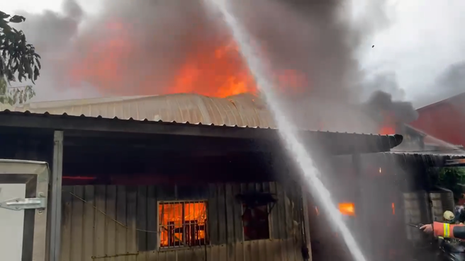三重鐵皮倉庫發生火警，現場濃煙衝天、火舌竄出。（翻攝畫面）