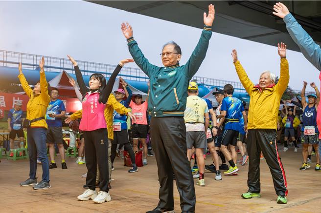 立法院长游锡堃出席2023板桥马拉松路跑赛，与参赛者一起热身。（立法院提供）