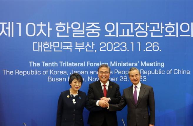 图为王毅（右）11月26日出席中日韩三国外长会议。（摘自大陆外交部网站）