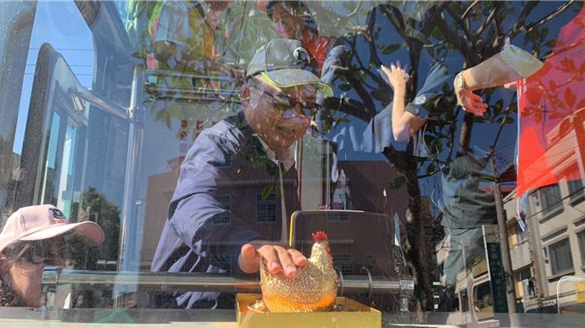 交通部观光署参山处长曹忠猷(如图)上车示范乘客摸紫南宫过火的金鸡母就可以祈求旅程替自己带来好财运。（曾雪蒨摄）