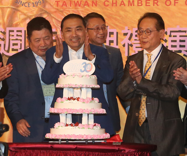 国民党总统参选人侯友宜（前左）28日出席台湾工商企业联合会理监事联席会议暨30周年庆联谊晚会，和台湾工商企业联合会理事长许显荣（前右）一起唱生日快乐歌，庆祝30周年会庆。（赵双杰摄）