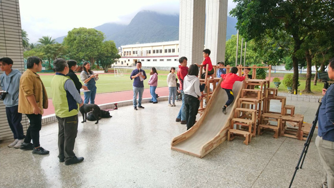 學童於組裝完成後的木積木溜滑梯上玩耍。(照片/大安高工提供)