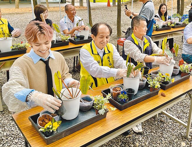 南投縣埔里鎮「2023花卉秋季展－花敘」29日舉行記者會，埔里鎮長廖志城（前排左二）與擁有200萬粉絲的YouTuber黃挺瑋（前排左一）在現場體驗DIY盆栽。（楊靜茹攝）