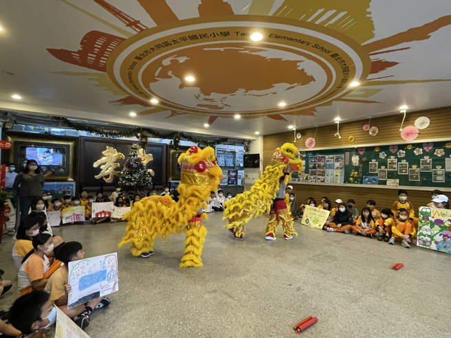 北市太平国小学生一早手持制作的欢迎海报于川堂等候，并由舞狮队的孩子以祥狮表演迎宾，在热闹氛围中揭开交流序幕。(北市太平国小提供)