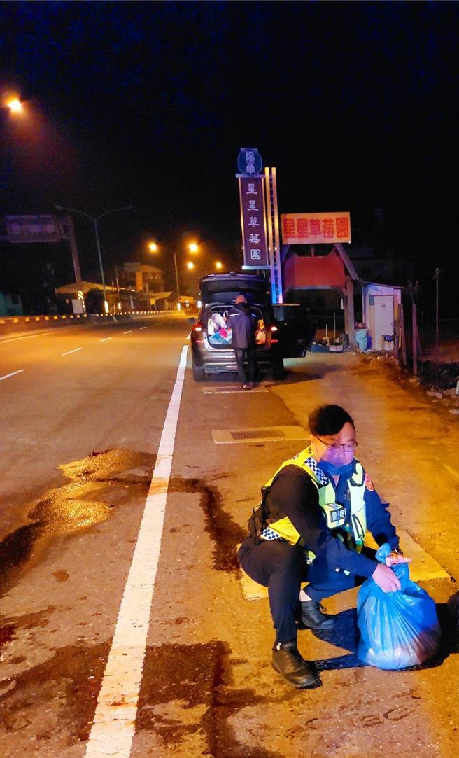 警员将散布在中潭公路上的肉块、内臟捡拾装袋，避免影响行车安全。（警方提供／杨静茹南投传真）