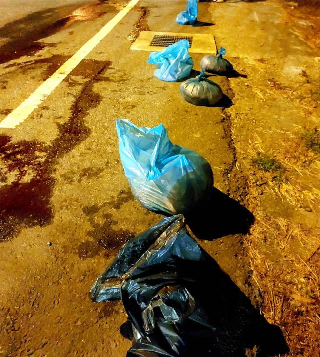 警方到场将掉落路面猪肉块、猪内臟打包，呼吁民眾呼吁民眾开车载运货物时，行前一定要检查货物有无綑绑牢固避免触法。（警方提供／杨静茹南投传真）
