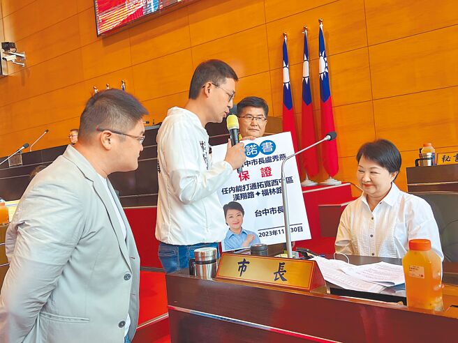 台中市议员林祈烽（左二）、施志昌（左一）及杨典忠（右二）11月30日在议会联合质询，要求市长卢秀燕（右一）签署承诺任内拓宽打通汉翔路、福林路的保证书，但卢笑着允诺却未签署。（林欣仪摄）