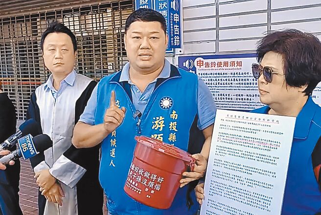 南投县立委二选区国民党籍参选人游颢（中）在律师苏文俊（左）等人陪同下，11月30日赴南投地检署控告对手蔡培慧及其团队涉嫌诬告、加重诽谤及意图使人不当选。（杨静茹摄）