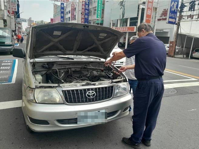 高雄一名男子的銀色轎車正好拋錨在派出所前，警察提著有「救車神器」之稱的車用行動電源，瞬間化解狀況。（警方提供／任義宇高雄傳真）
