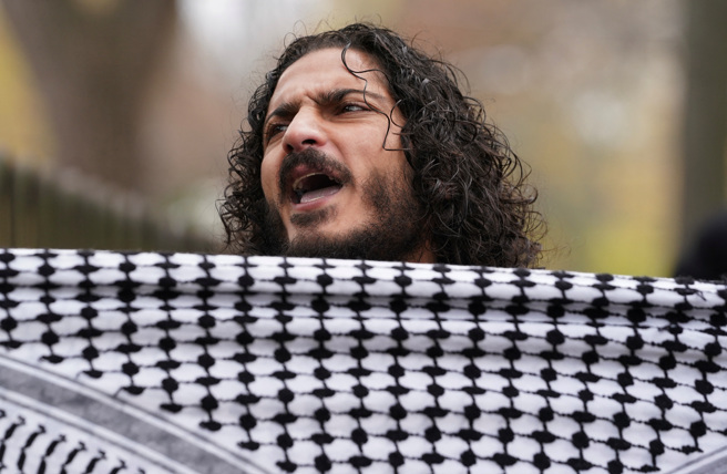 2023年12月1日，一名親巴勒斯坦抗議者在美國華盛頓以色列大使館外參加集會。（路透社）
