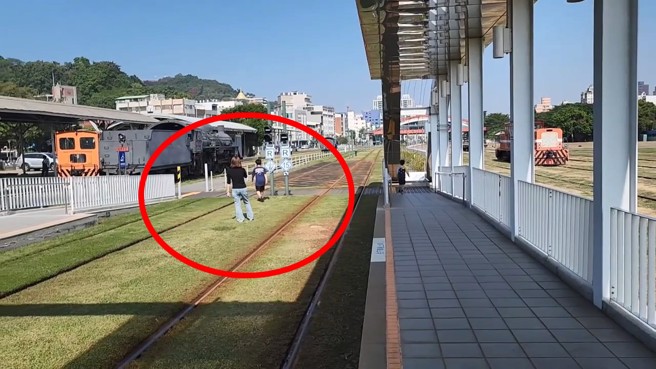 家長帶小孩在高雄輕軌的軌道上違規跨越拍照。（翻攝爆料公社）