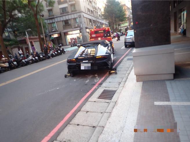 藍寶堅尼超跑違停於新北市板橋區廣和路，拖吊人員立即替超跑裝上輔助輪，花了不到10分鐘時間，將超跑吊離現場。（民眾提供）