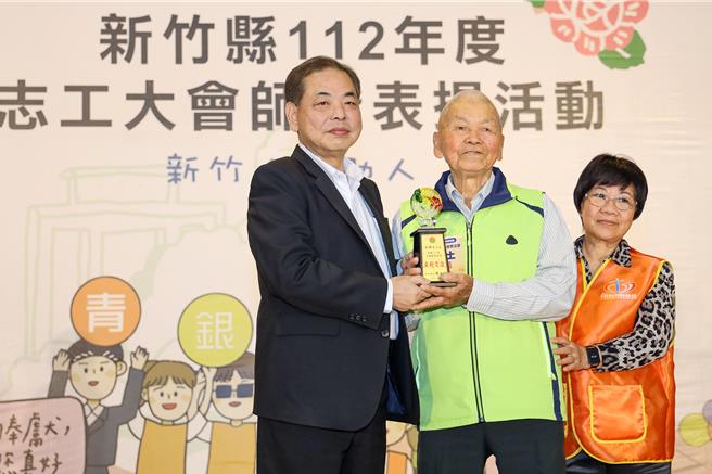 新竹縣政府3日舉辦志工大會師暨表揚活動，副縣長陳見賢（左）頒獎給最高齡「型男志工」102歲的宋增土（中） ，是藝人田馥甄的外公。（羅浚濱攝）