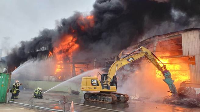 火警现场动用怪手协助破坏铁皮。（消防局提供）