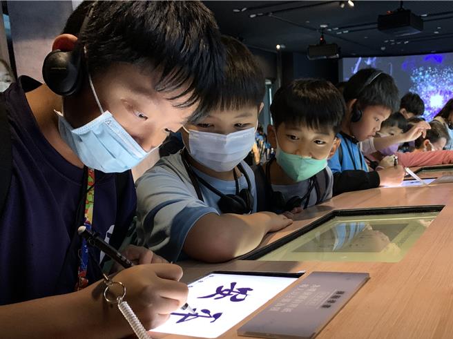 小朋友认真用e笔学习王羲之平安帖。（故宫南院提供∕吕妍庭嘉义传真）