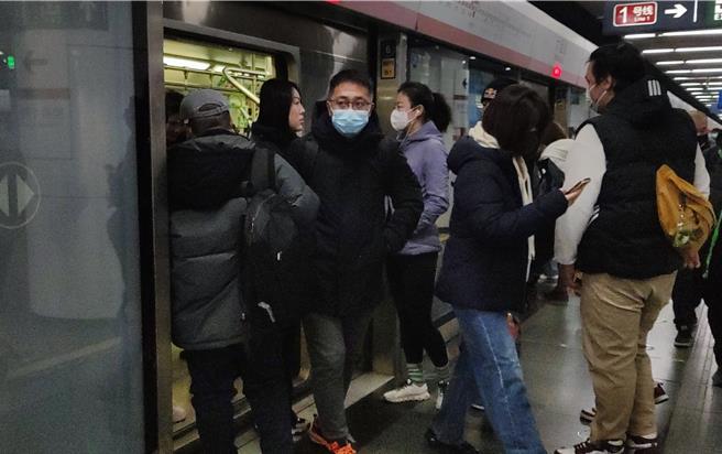 大陸近期急性呼吸道疾病傳染升溫，讓北京又重新戴回口罩，圖為4日地鐵站內人潮。（吳泓勳攝）