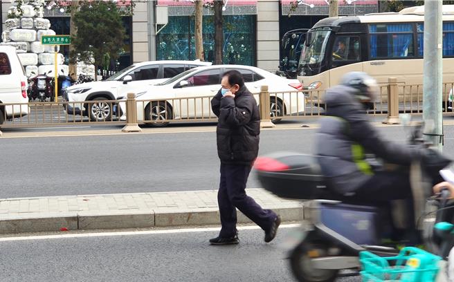 大陸近期急性呼吸道疾病傳染升溫，4日北京一名長者走在路上趕緊戴上口罩。（吳泓勳攝）