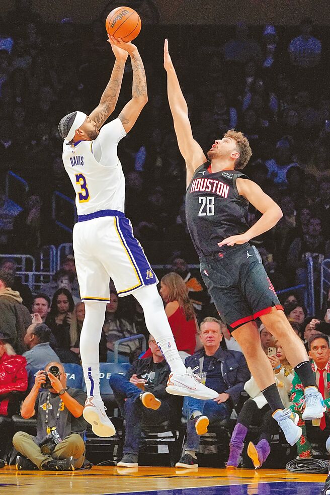 安東尼戴維斯（左）無視申京把手伸長防守照樣投籃。（美聯社）