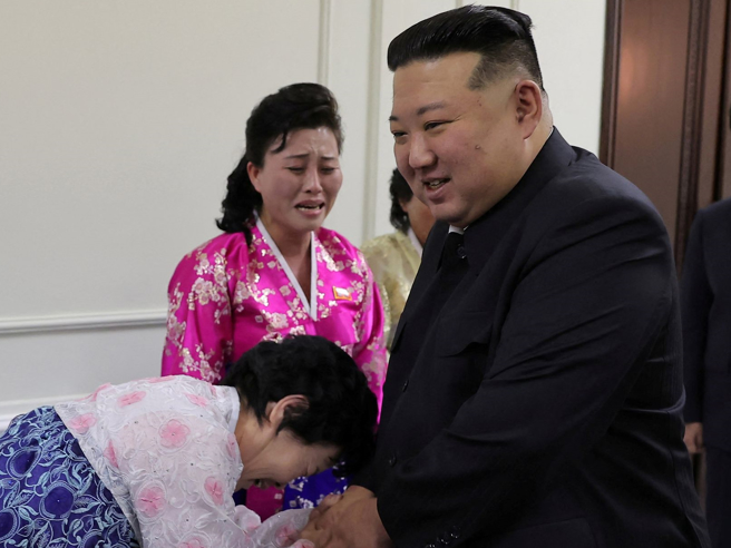 北韩最高领导人金正恩12月5日在平壤全国母亲大会中和支持者寒暄。（路透）