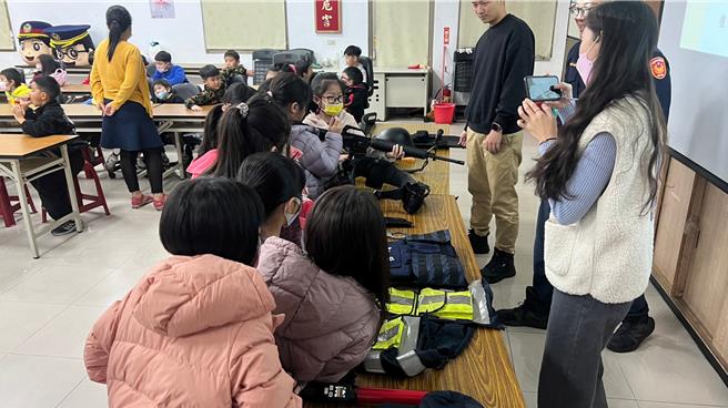 桃園市楊梅國小校外教學參訪楊梅警分局，警方介紹勤務裝備、分享法制觀念。（翻攝照片／蔡明亘桃園傳真）