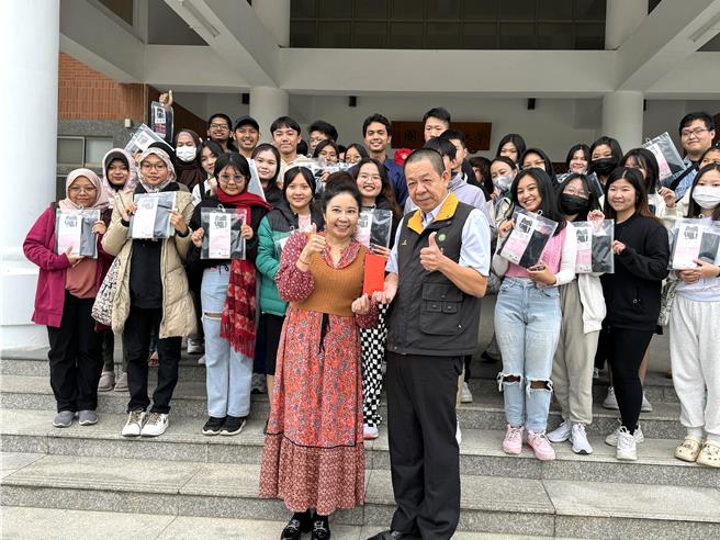 金大国际处国际长顏郁芳(前排左)将冬衣募集活动募得的10200元捐赠给金门家扶中心，由中心主任李桂平(前排右)代表接受。(于家麒摄)