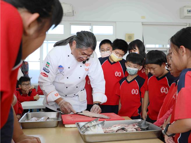 在大厨指导下，学童学习酥炸乌鱼块、了解乌鱼是如何由产地到餐桌。（吕妍庭摄）