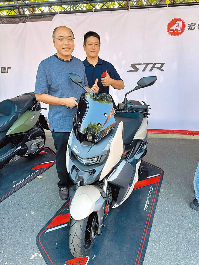 宏佳腾动力科技副总经理锺登凯（左），到南臺车展自家展区加油打气，并与销售人员及广为车友讨论热烈的STR黄／白牌油车合影。图／郭文正