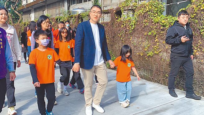 基隆市玛陵国小校门口附近柏油马路长期因下雨出现坑洞，经基市工务处整建完工，市长谢国梁（右三）与学生7日一起体验完成改善的道路。（徐佑升摄）