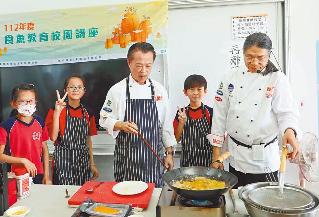 嘉义县长翁章梁（中）、大厨吴文智（右一）带着30名学童一起学习乌鱼知识、如何炸乌鱼块。（吕妍庭摄）